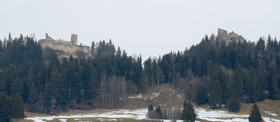 Le opposte rovine dei castelli Eisenberg e Hohenfreyberg su colline boscose nell’Ostallgäu
