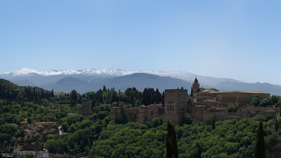 Vista panoramica dell’Alhambra di Granada davanti allo sfondo montuoso.
