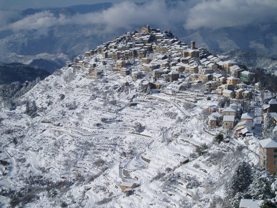 Vista di Bajardo nella provincia di Imperia con case e pendii innevati