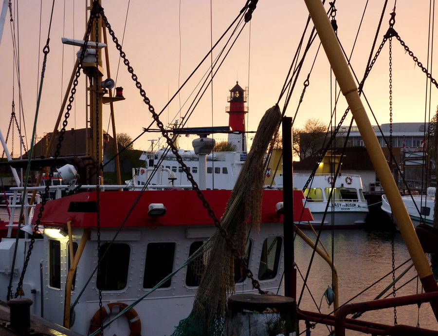 Porto di Büsum con barche e faro al tramonto