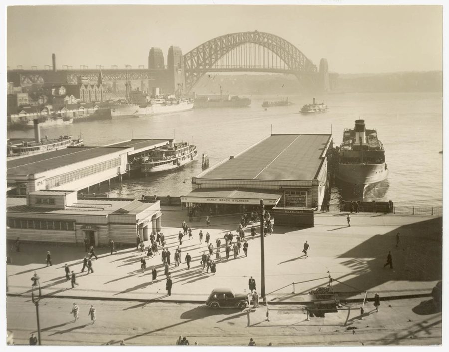 I passeggeri lasciano il traghetto per Manly a Circular Quay davanti all’Harbour Bridge