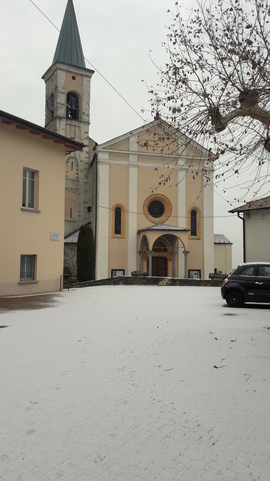 Panorama di Germasino con chiesa, locale associativo e municipio davanti al paesaggio montano