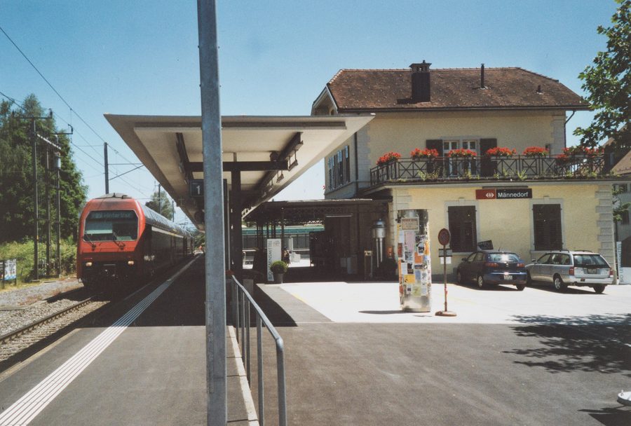 Edificio della stazione di Männedorf con pensilina del marciapiede e treno S-Bahn