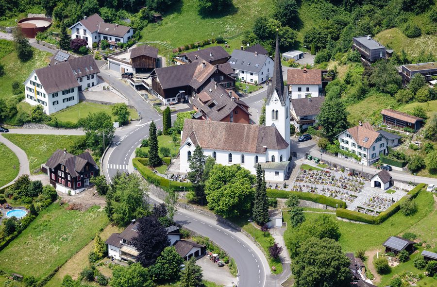 Veduta aerea della chiesa parrocchiale di Santa Agnese e del cimitero a Klaus nel Vorarlberg