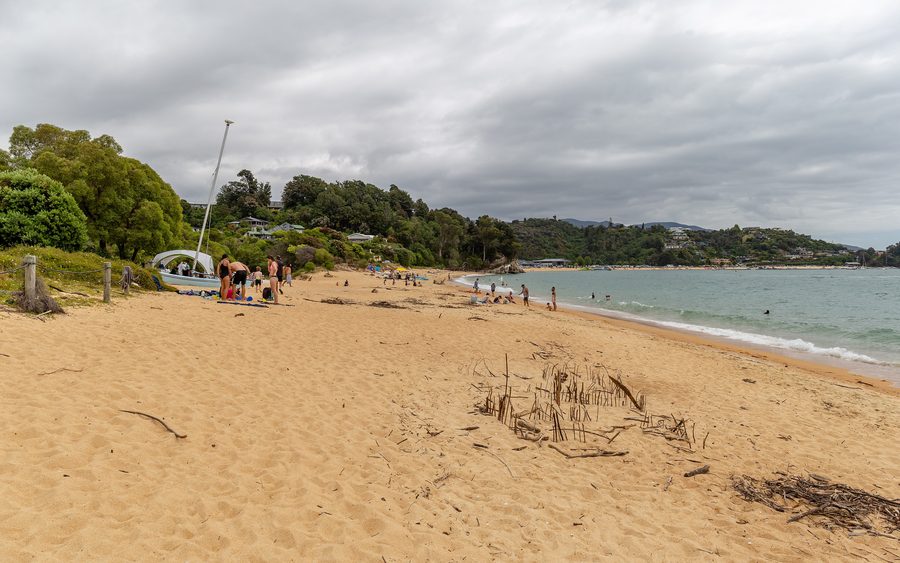 Spiaggia sabbiosa a Little Kaiteriteri con acqua azzurra e tranquilla.