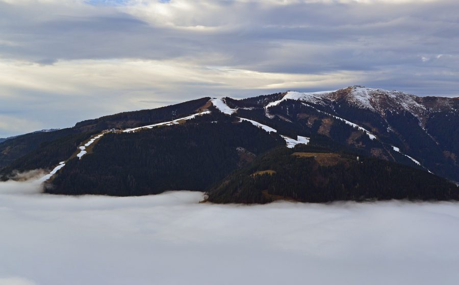 Schmittenhöhe sopra Zell am See con la nebbia che copre il bacino, il lago e la città