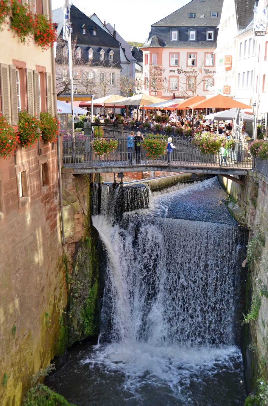 Famosa cascata a Saarburg con visitatori in una luminosa giornata autunnale