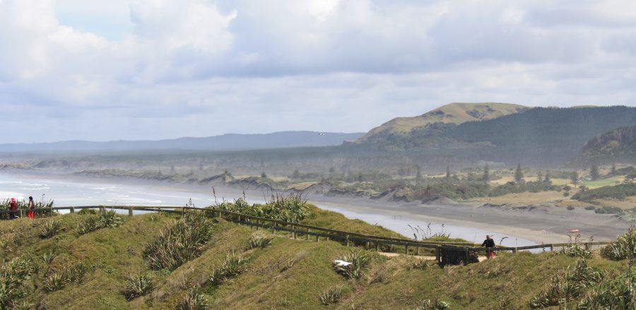 Muriwai Beach con sabbia nera e costa rocciosa in Nuova Zelanda